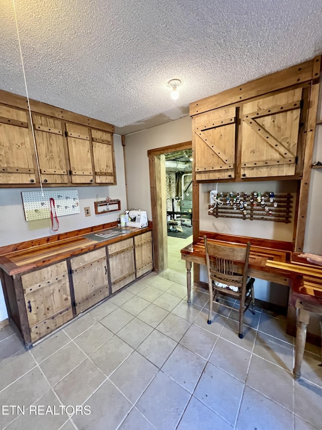 kitchen featuring a textured ceiling and light tile patterned flooring