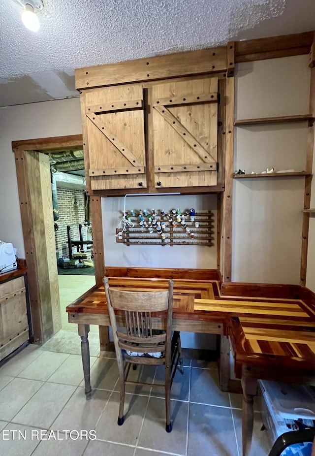 tiled dining area with a textured ceiling