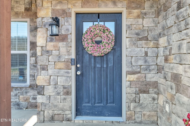 property entrance featuring stone siding