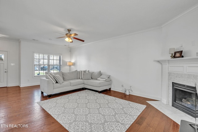 living area featuring dark wood finished floors, a ceiling fan, and ornamental molding