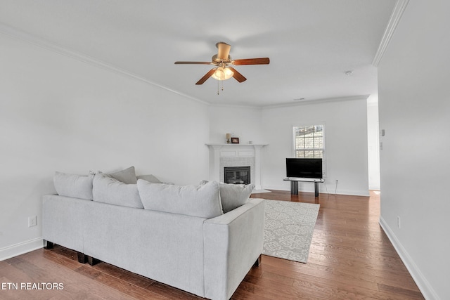 living room featuring a ceiling fan, a fireplace with flush hearth, dark wood-style floors, and baseboards