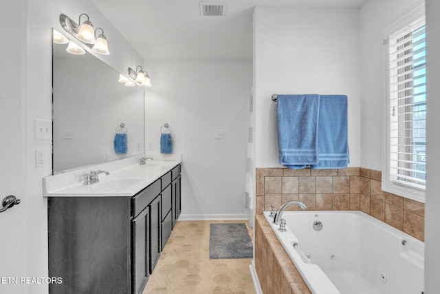 full bathroom with visible vents, a jetted tub, baseboards, double vanity, and a sink