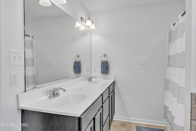 full bathroom featuring a sink, curtained shower, baseboards, and double vanity