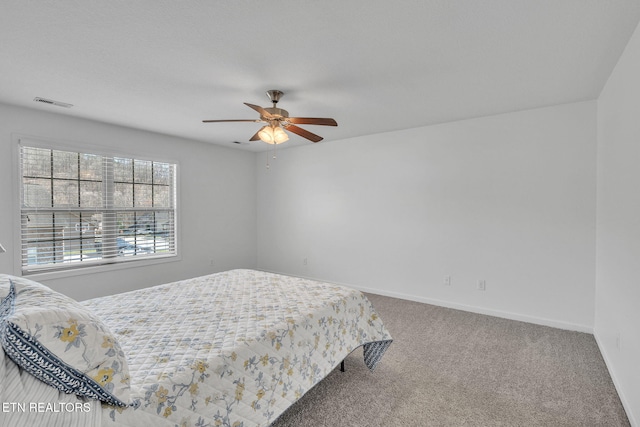 carpeted bedroom featuring visible vents, ceiling fan, and baseboards