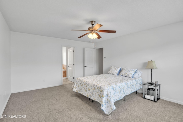 carpeted bedroom featuring connected bathroom, baseboards, and ceiling fan