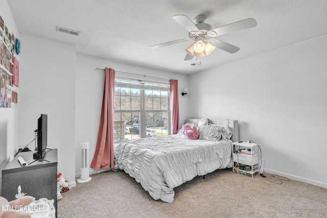 carpeted bedroom featuring visible vents, baseboards, a textured ceiling, and ceiling fan