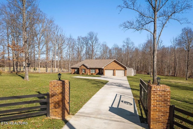 view of front facade featuring a front lawn, concrete driveway, and fence