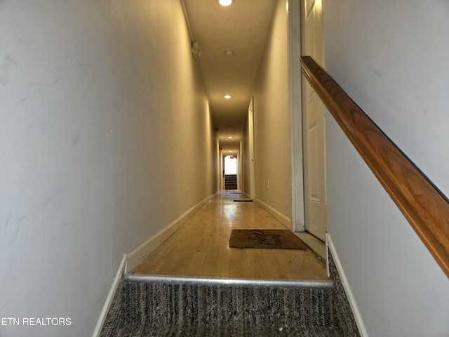 corridor featuring wood finished floors, recessed lighting, and baseboards