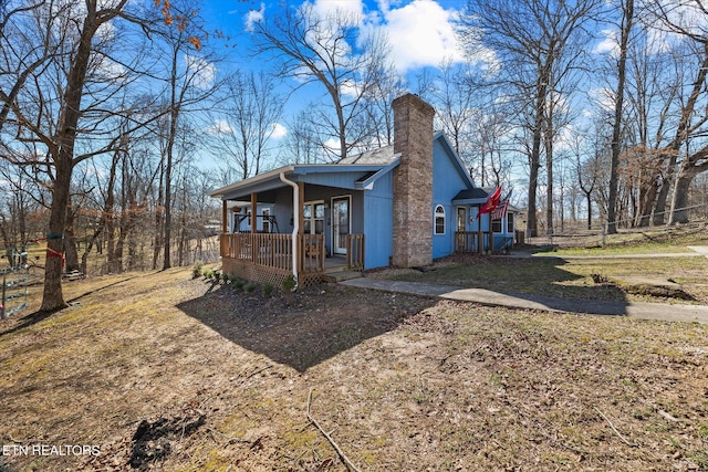 exterior space with a porch and a chimney