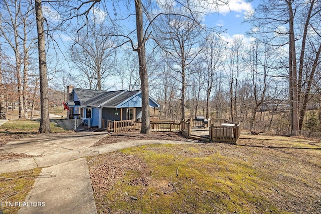 view of front of property featuring a chimney and fence