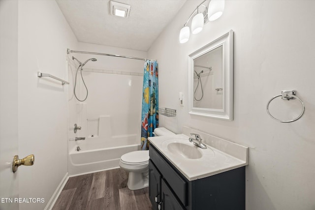 full bath featuring shower / tub combo with curtain, toilet, a textured ceiling, wood finished floors, and vanity