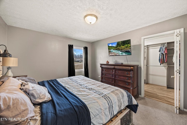 bedroom featuring light carpet and a textured ceiling