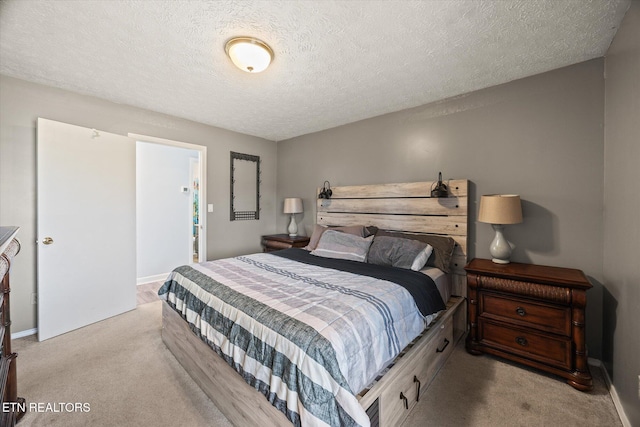 bedroom with light colored carpet, a textured ceiling, and baseboards