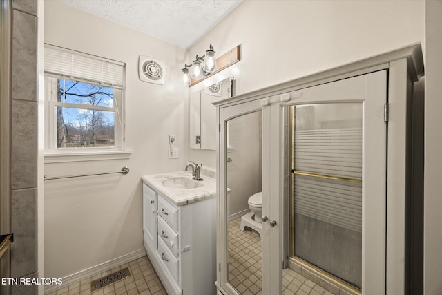 bathroom featuring visible vents, toilet, vanity, tile patterned floors, and a textured ceiling