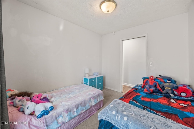 carpeted bedroom with baseboards and a textured ceiling