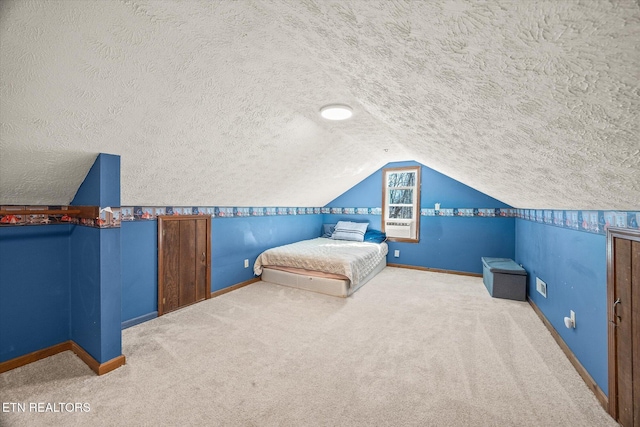 unfurnished bedroom featuring lofted ceiling, carpet, baseboards, and a textured ceiling