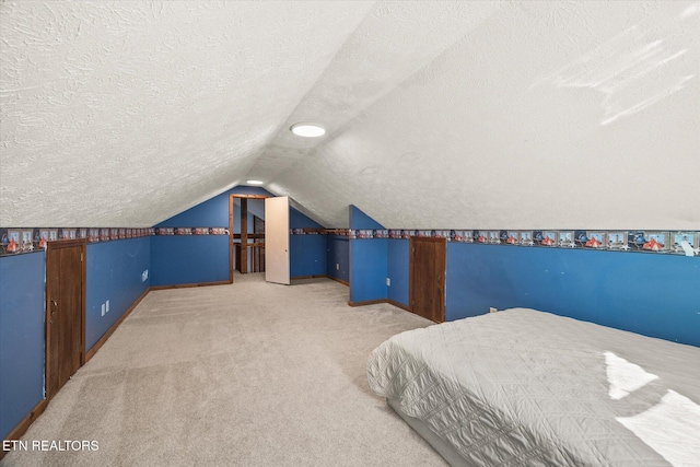 carpeted bedroom featuring vaulted ceiling, baseboards, and a textured ceiling