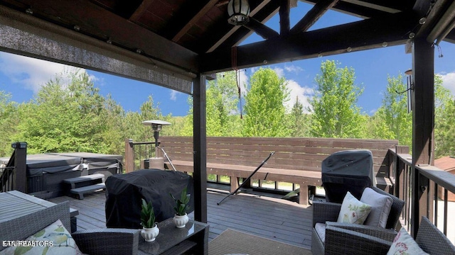 wooden deck with area for grilling and a hot tub