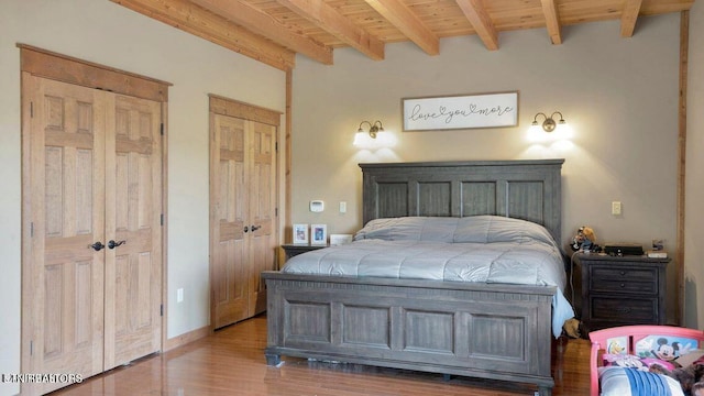 bedroom featuring wooden ceiling, beamed ceiling, wood finished floors, and baseboards