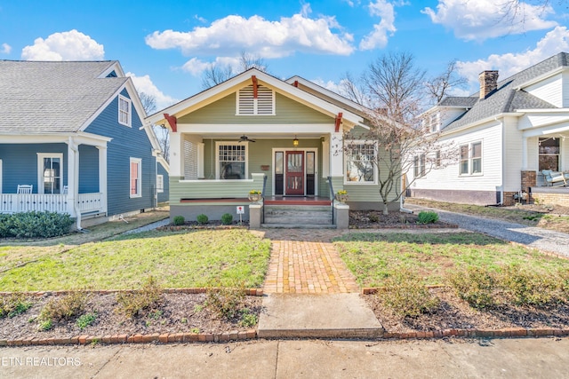 view of front facade featuring a porch, a ceiling fan, and a front lawn