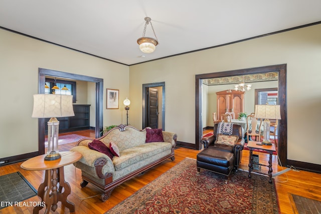 living area with crown molding, baseboards, and wood finished floors