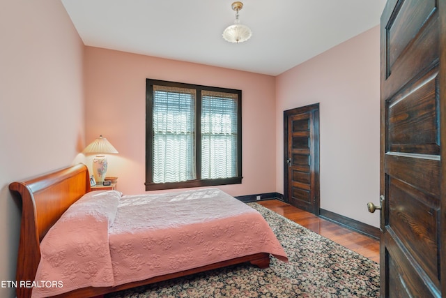 bedroom featuring baseboards and wood finished floors