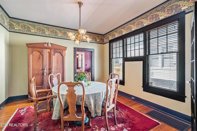 dining space featuring visible vents, baseboards, and wood finished floors