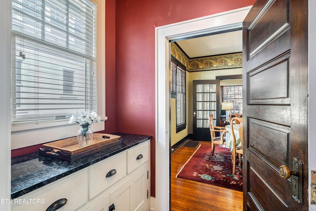 kitchen with white cabinetry, dark stone counters, dark wood-style floors, and baseboards