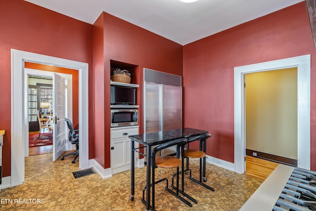 kitchen with white cabinets, baseboards, and appliances with stainless steel finishes