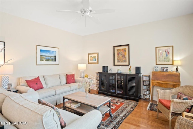 living area with ceiling fan and wood finished floors