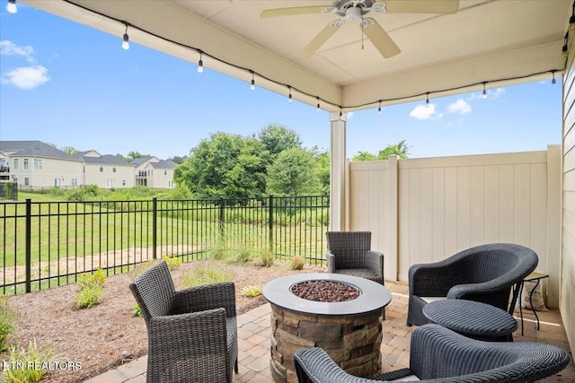 view of patio featuring a fenced backyard, a residential view, an outdoor fire pit, and ceiling fan