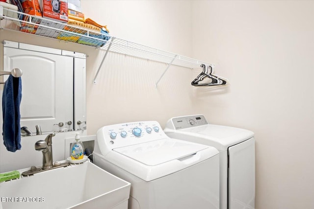 laundry area featuring washer and dryer, laundry area, and a sink