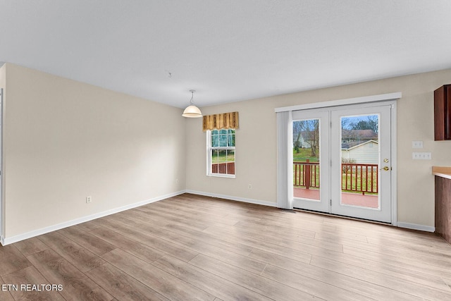 interior space featuring light wood-type flooring and baseboards