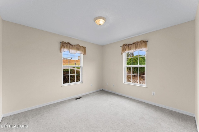 unfurnished room featuring plenty of natural light, baseboards, and carpet