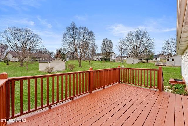 wooden deck with a yard, an outbuilding, a storage shed, and a residential view