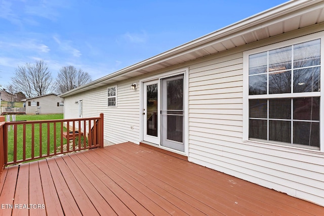 wooden deck featuring a lawn