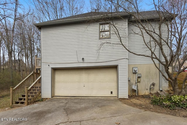 view of property exterior with stairway, driveway, and an attached garage