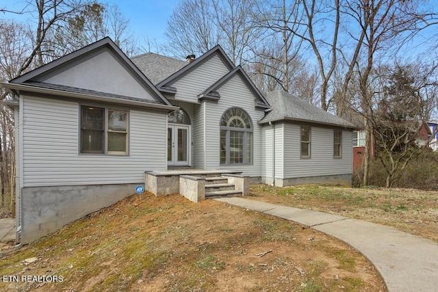 view of front of house with french doors and roof with shingles