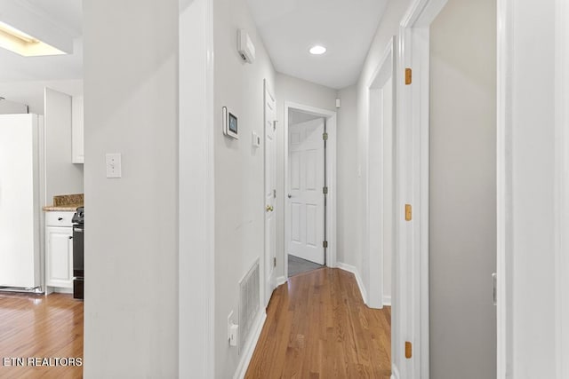 corridor featuring visible vents, recessed lighting, light wood-type flooring, and baseboards