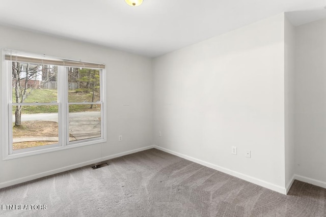 empty room with visible vents, carpet, and baseboards