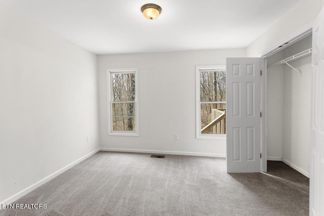 unfurnished bedroom with carpet flooring, baseboards, and visible vents