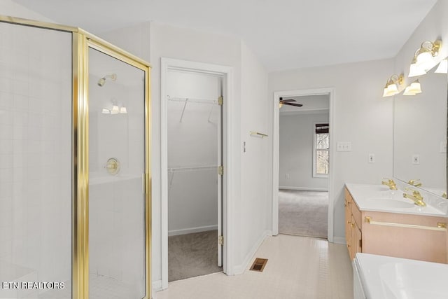 full bath with a walk in closet, visible vents, a stall shower, baseboards, and vanity