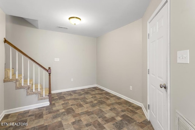 interior space with visible vents, baseboards, stairway, and stone finish flooring