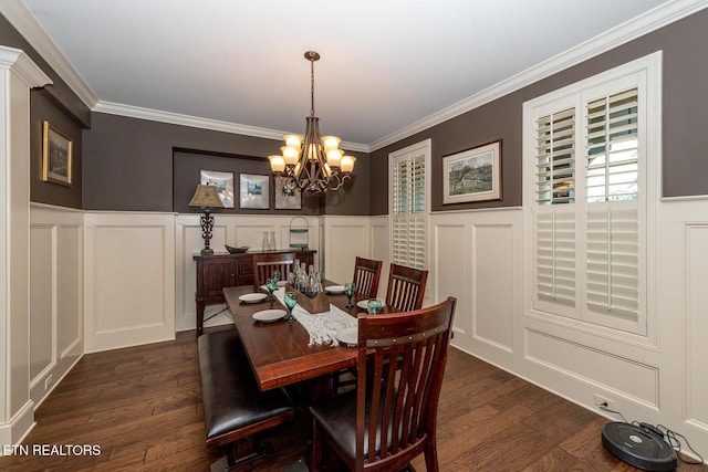 dining area featuring a chandelier, ornamental molding, dark wood-style flooring, and a decorative wall