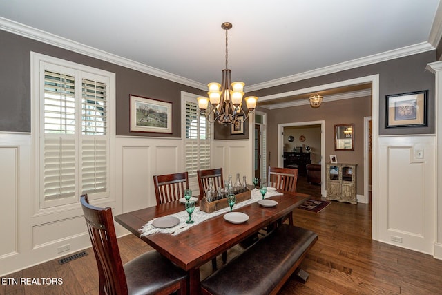 dining space featuring visible vents, dark wood-style floors, crown molding, and a decorative wall