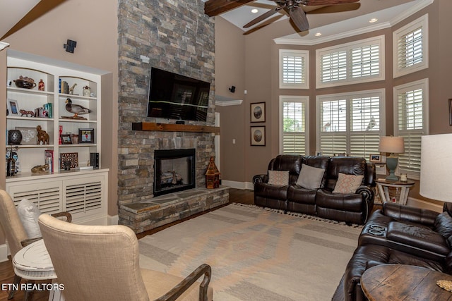 living room with high vaulted ceiling, wood finished floors, a fireplace, and ornamental molding