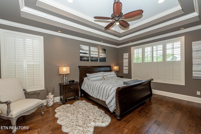 bedroom with a tray ceiling, baseboards, wood-type flooring, and ornamental molding