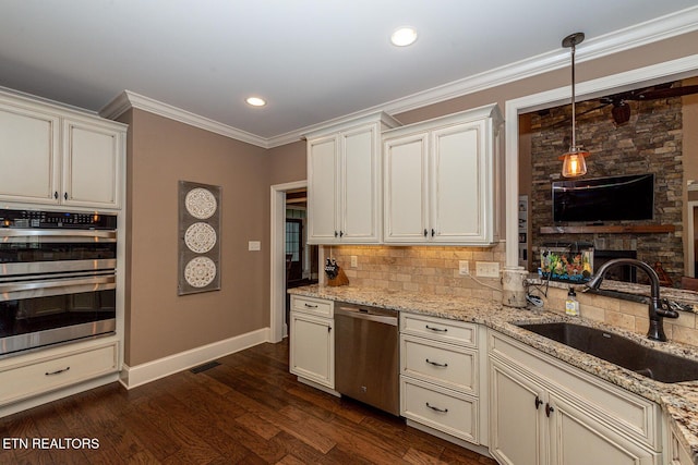 kitchen with a sink, ornamental molding, dark wood-type flooring, stainless steel appliances, and backsplash