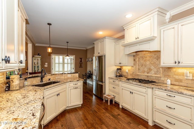 kitchen featuring dark wood-style floors, ornamental molding, stainless steel appliances, and a sink