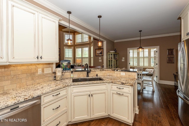 kitchen featuring a peninsula, a sink, ornamental molding, stainless steel appliances, and backsplash